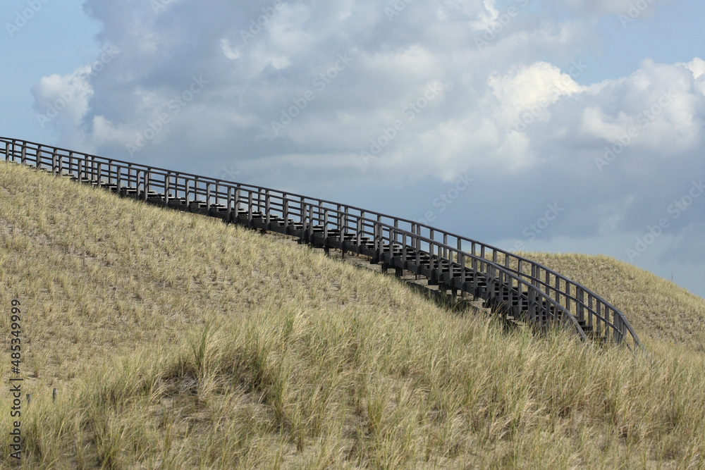 A wooden stairway in the dunes of Petten, the Netherlands, leading to a viewing point
