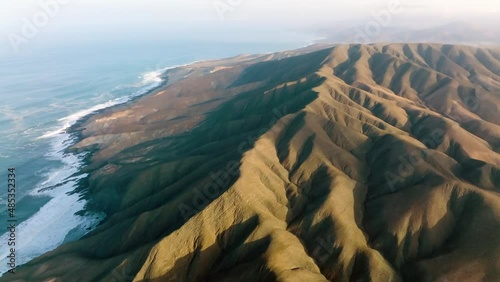 Top view of Montana Cardon National Park. Drone flight over the beautiful island mountains. Beautiful fuerteventura island. Mountains meet Atlantic ocean. Canary islands video. 4k photo