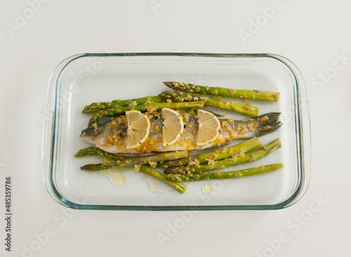 Raw marinated seabass with asparagus before baking