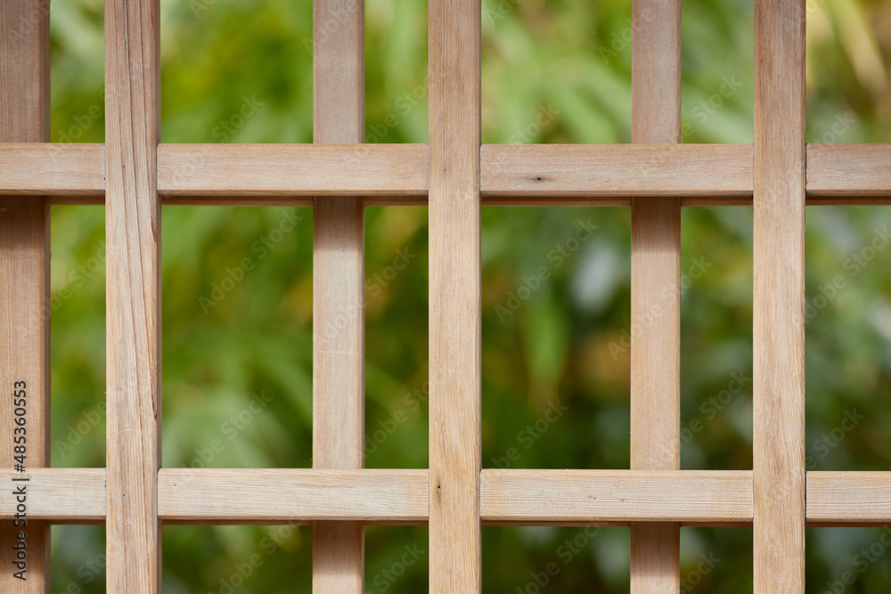 A close-up of a wooden gate with a dark green background A close-up of a wooden gate with a dark green background