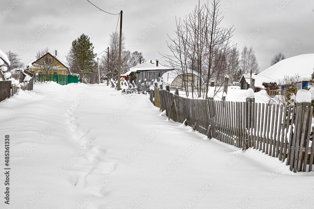 Rustic path to the house, covered with deep snow.