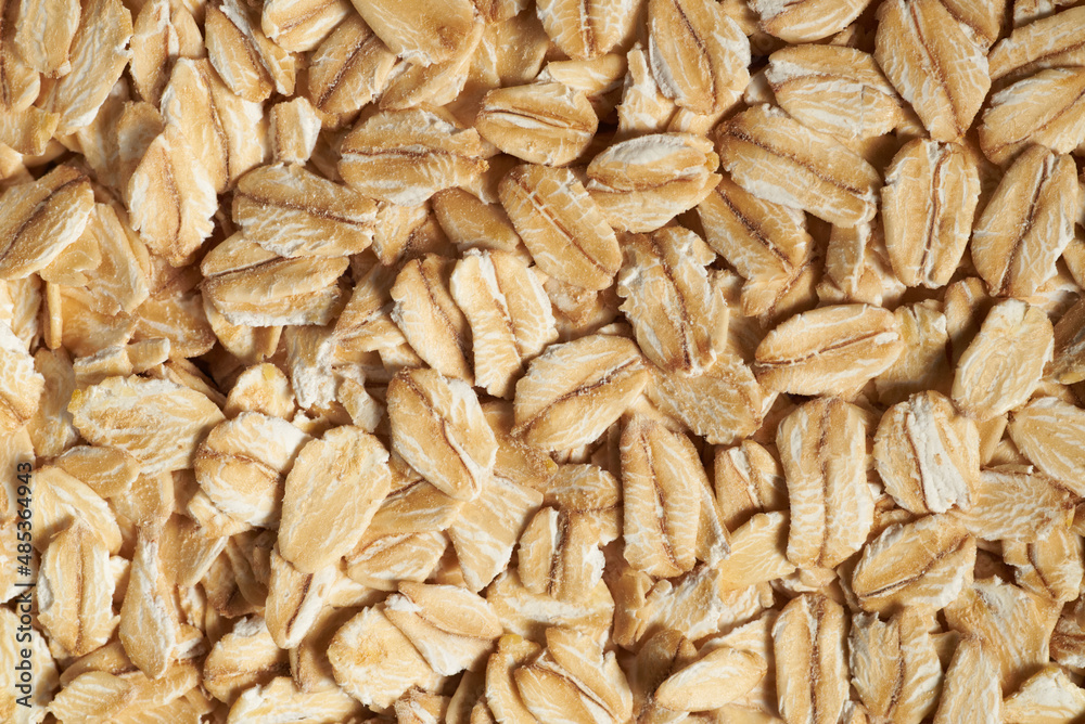 Rolled oat flakes background. Overhead view macro photo with shallow depth of field. Rolled oat flakes background. Overhead view macro photo with shallow depth of field.