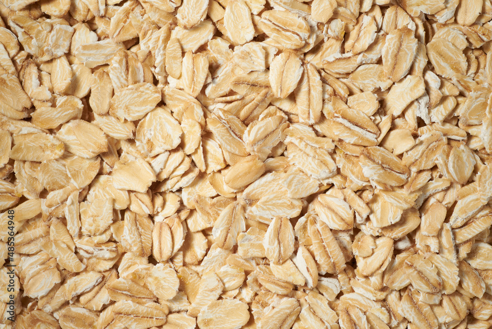 Rolled oat flakes background. Overhead view macro photo with shallow depth of field.