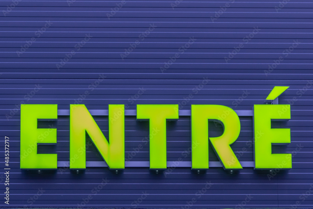 Green enter sign on blue background wall. Green enter sign on blue background wall.