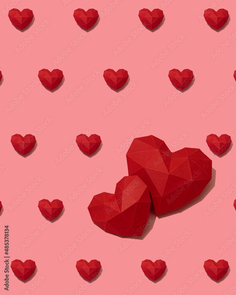 Red paper hearts pattern on pink background