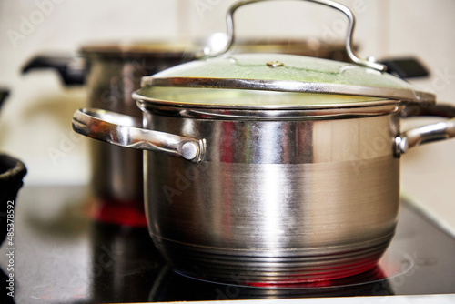 Lunch or dinner is cooked on the stove in a frying pan and pots