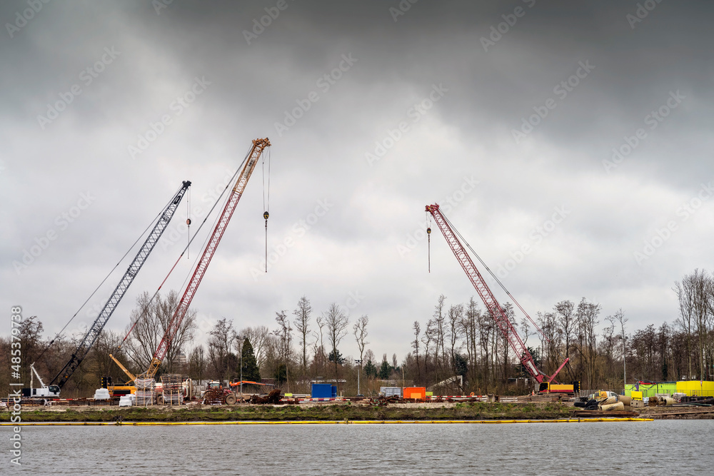 Tower cranes works on building site on the dramatic sky background