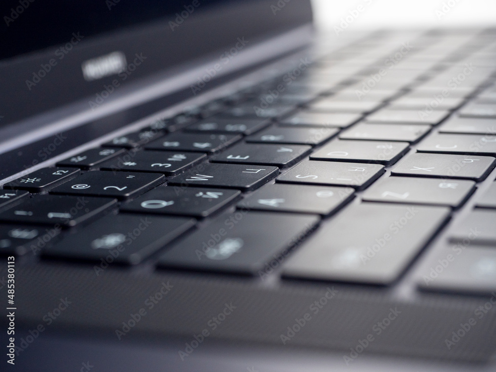 Close-up of the keyboard of an open laptop. Selective focus. Modern devices for work and leisure