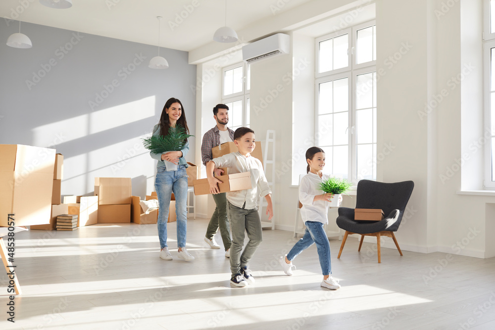 Happy young family with little children bring boxes enjoy moving day to new home. Smiling parents with small kids unpack unbox relocate to own house. Rent and realty, real estate concept.