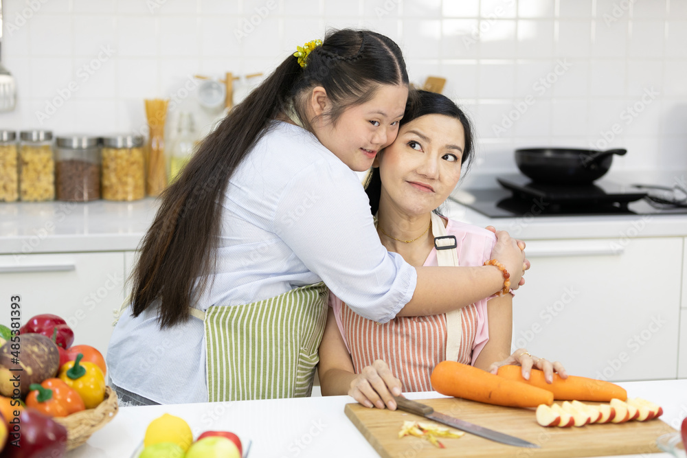 down syndrome teenage girl hugging her mother in the kitchen down syndrome teenage girl hugging her mother in the kitchen