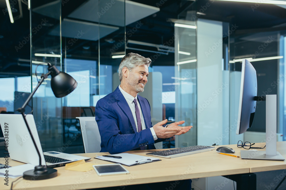 Senior and experienced employee, advises the buyer on a video call, the man works in a modern office uses webcam