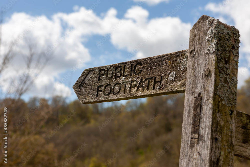 Old wooden public footpath signpost at the foot of the beech hanger called Battines Hill Wood, near East Marden, South Downs National Park, West Sussex, UK
