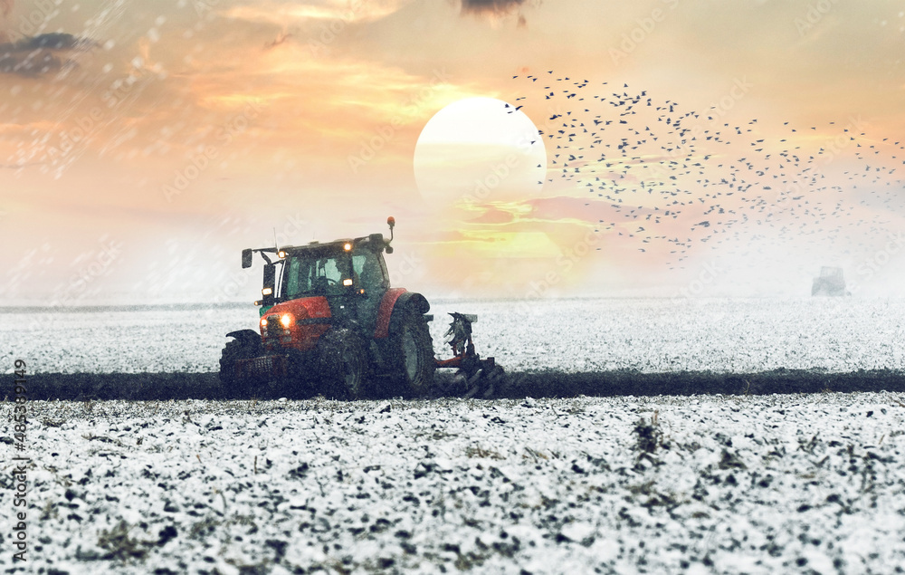 Fototapeta premium Tractor plowing a field in winter