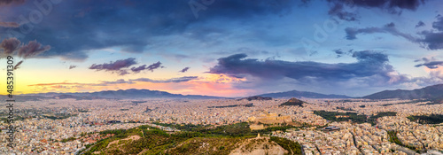 Aerial drone panoramic view of the Greek capital Athens at sunset with a sky overcast with storm clouds, Greece, Europe. View of the city from above