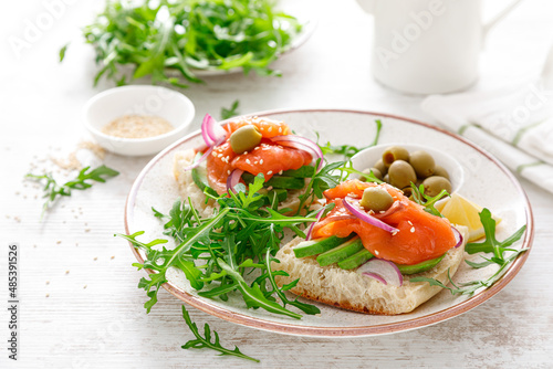 Open sandwiches with salted salmon, avocado, olives and arugula. Breakfast