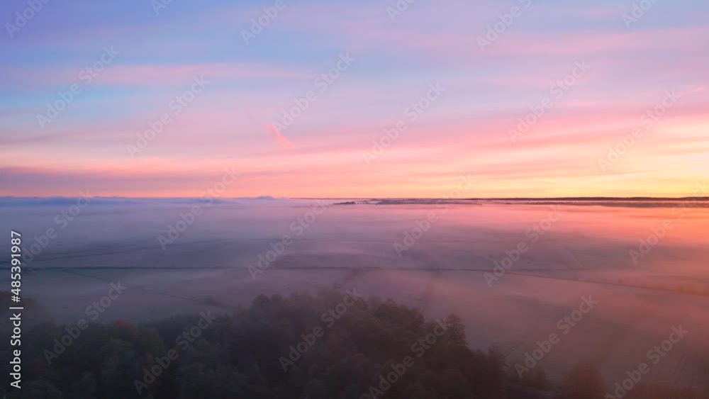 Aerial landscape of the foggy morning at the forest and fields. Orange sun and beautiful pastel colors in the sky during autumn sunrise. Aerial landscape of the foggy morning at the forest and fields. Orange sun and beautiful pastel colors in the sky during autumn sunrise.