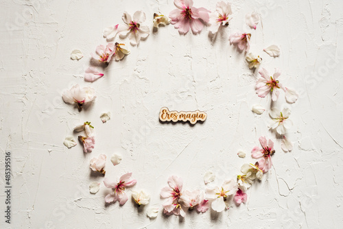 Romantic white background of almond flower wreathwith words written on wood 