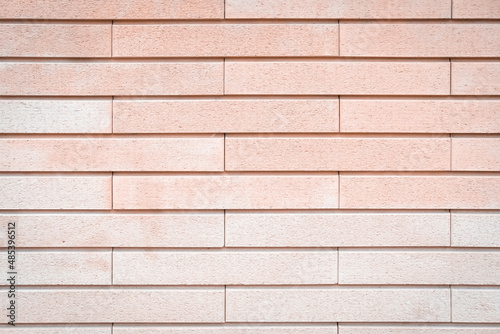 Pink and peachy brick wall texture background. Pastel tones. Beautiful, stylish, tender backdrop. Bright stone structure covered with stucco and paint. Construction material. Close up, copy space