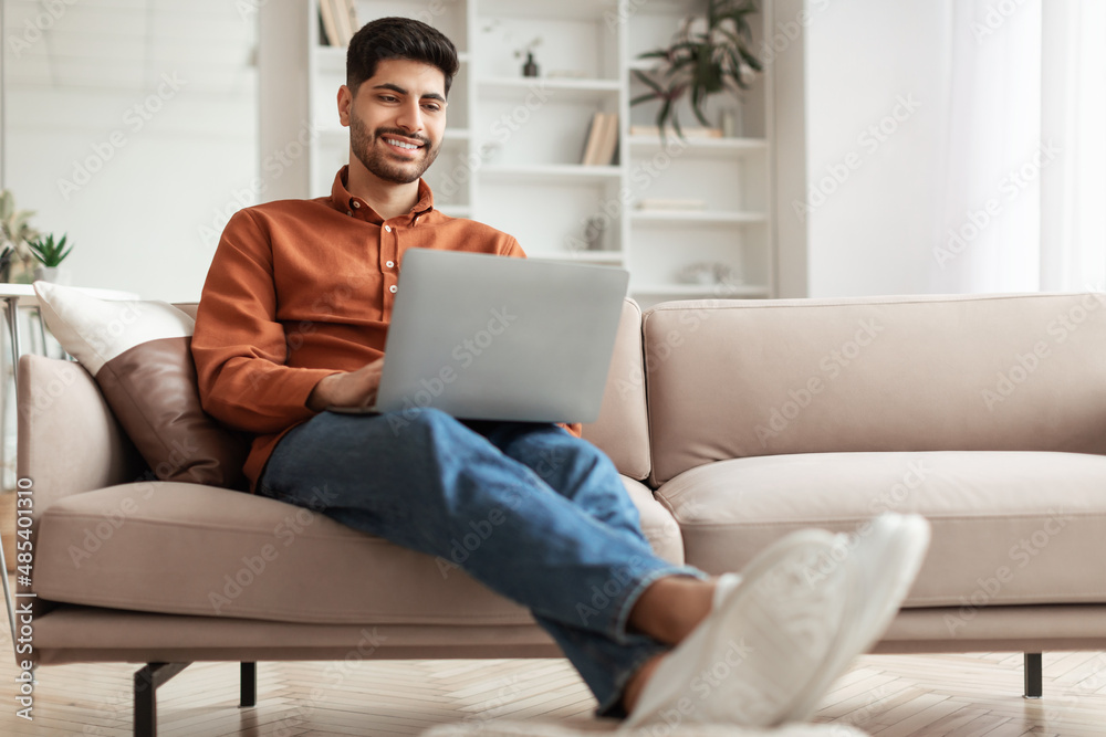 Portrait of smiling Arab man using pc at home