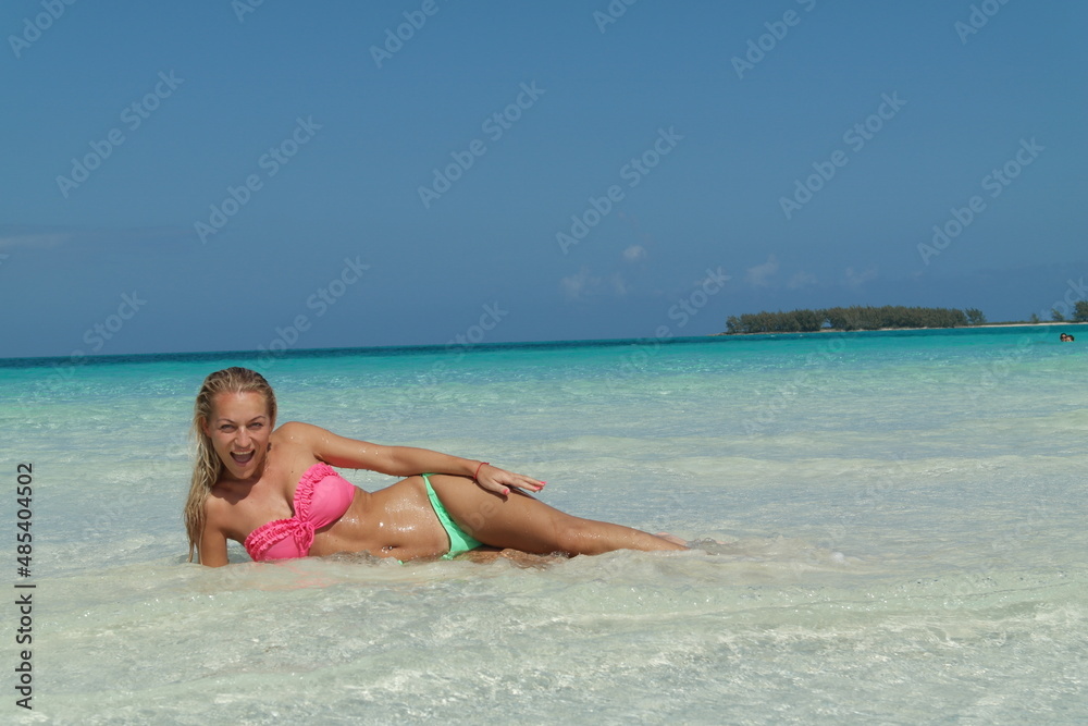 beautiful Blond Hair Young,  sporty body and sexy girl woman in bikini posing relaxing on the tropical beach in caribbean