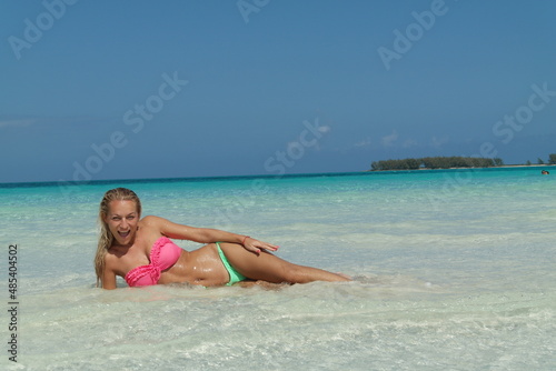 beautiful Blond Hair Young, sporty body and sexy girl woman in bikini posing relaxing on the tropical beach in caribbean