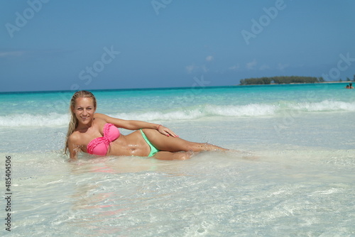 beautiful Blond Hair Young, sporty body and sexy girl woman in bikini posing relaxing on the tropical beach in caribbean