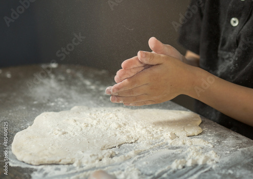 children's hands make dough on the table close-up