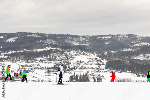 narciarze na szczycie stoku narciarskiego