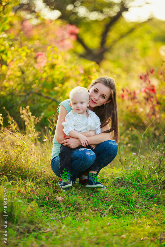 Fototapeta premium mom came and hugs her son against the backdrop of nature