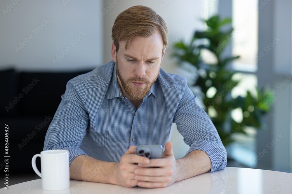 Caucasian man at home using a cell phone Caucasian man at home using a cell phone