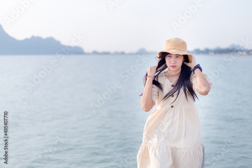 Asian woman wearing a brown hat,A beautiful smiling Asian woman with dark hair shows true positive emotions. Looks happy when wearing fashionable clothes. © banjongseal324