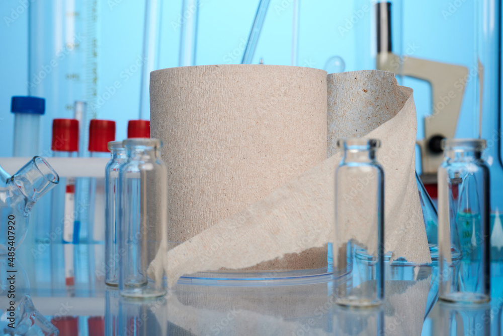 Toilet paper roll on lab desk. Photo with blue gradient background