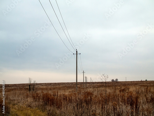 poles with electrical wires stand in the field