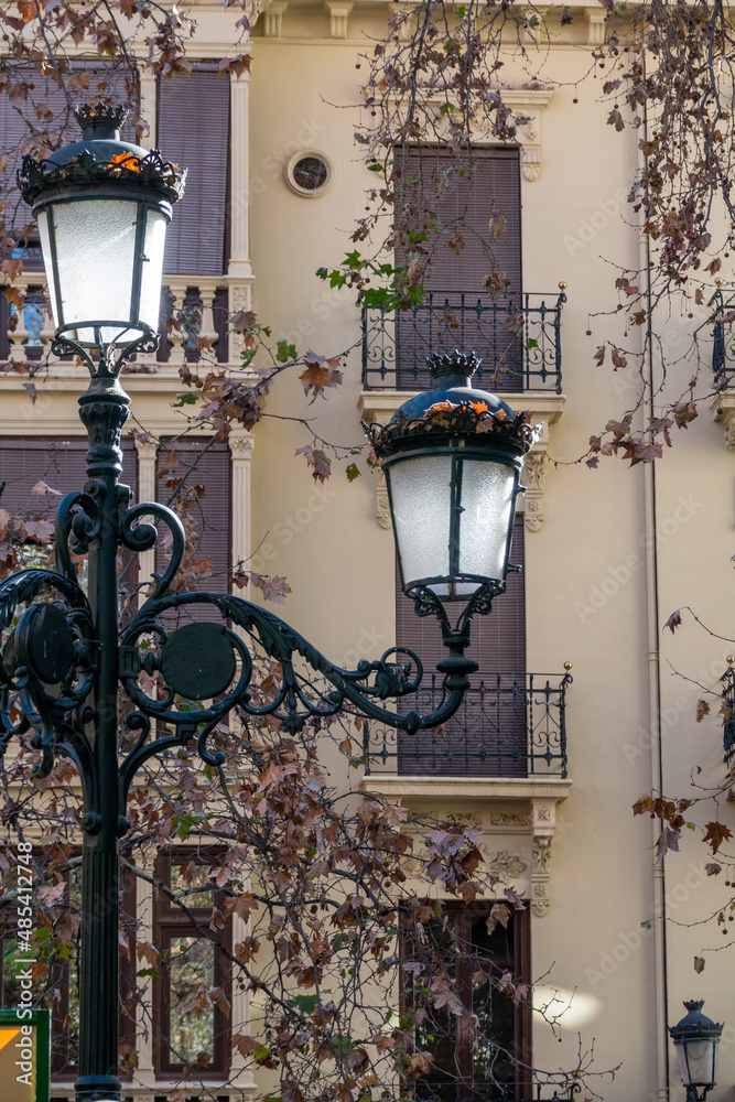 Old lampposts between autumn trees in an Andalusian street