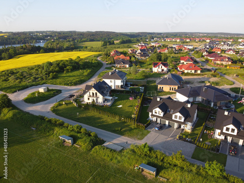 Residential neigborhood in sunset, bird eye view. Suburbs or village streets with luxury house buildings