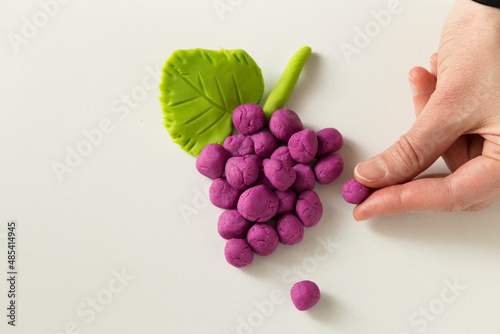 Making grape game step by step with dough for children's activity in the school art lesson and plasticine concept.