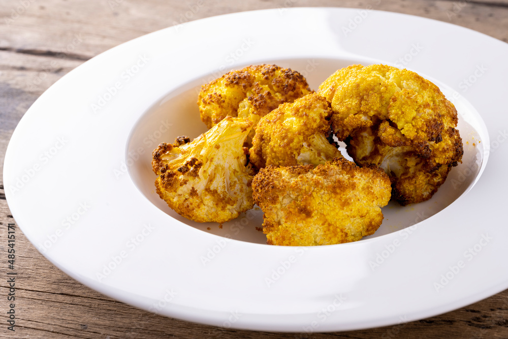 baked cauliflower with curry on white plate baked cauliflower with curry on white plate