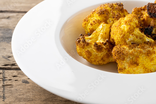 baked cauliflower with curry on white plate