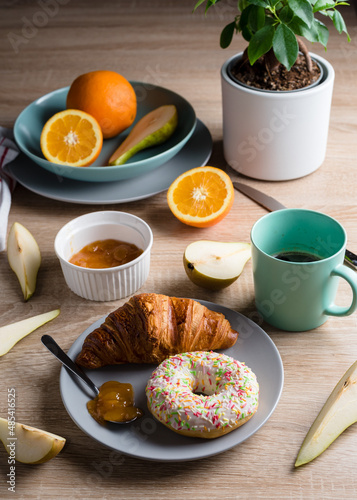 Healthy breakfast. Croissant, donut, coffee, jam, fruits: oranges and pears.