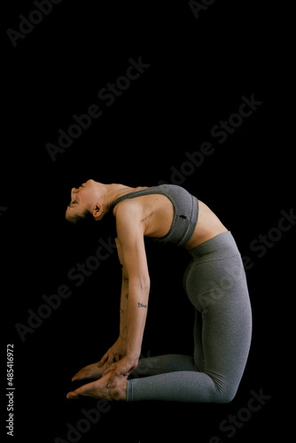 Woman doing yoga in black background. Ashtanga, Vinyasa, Hatha