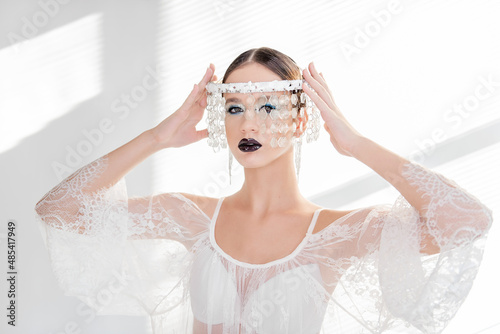 Fashion beauty close-up portrait of girl with black glossy lips, blue eyeshadows. crown of crystals