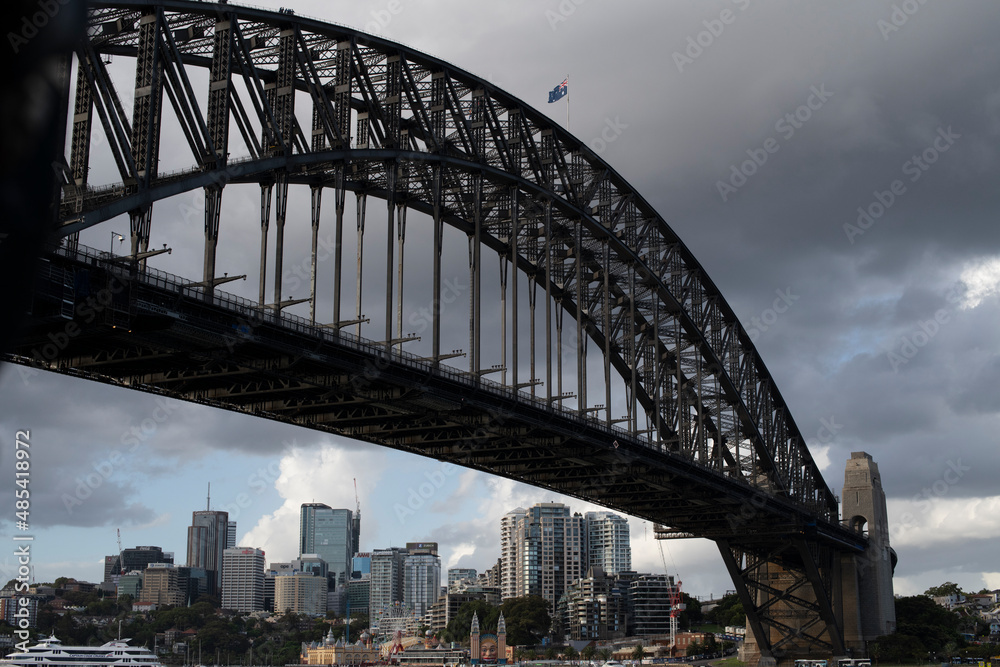 Fototapeta premium View of Sydney Harbour Bridge from the city to McMahons Point, Sydney, Australia. Scene shows Lunar Park, North Sydney Central Business District, cranes, cruise boat