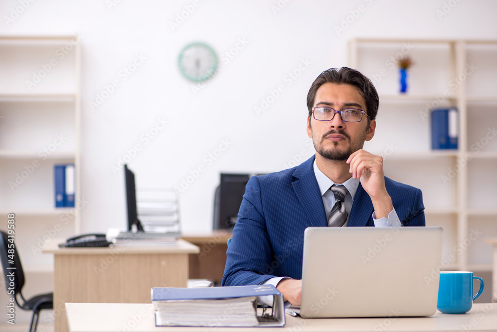 Young male employee working in the office Young male employee working in the office
