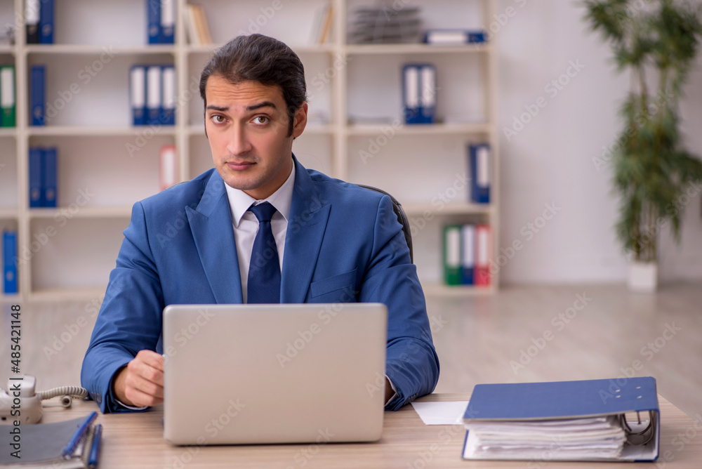 Young male employee sitting in the office Young male employee sitting in the office
