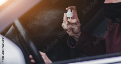 Driver spraying antibacterial sanitizer spray