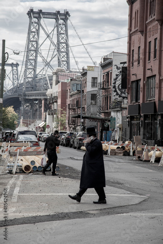 Jewish man crosses a street in Williamsburg with worksite , New York City