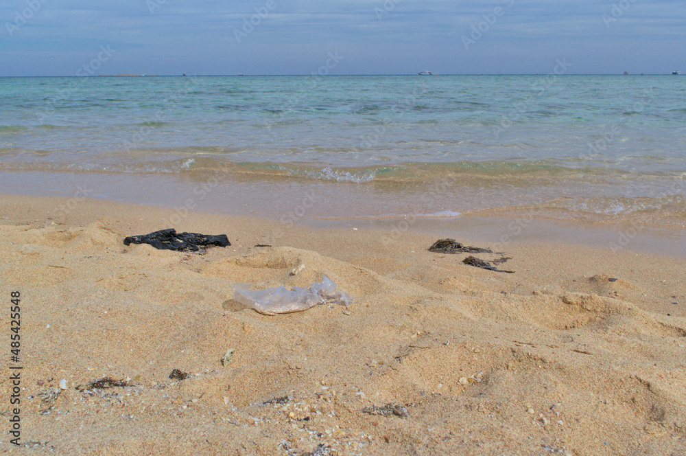 Plastic garbage bags on the sandy seashore Plastic garbage bags on the sandy seashore