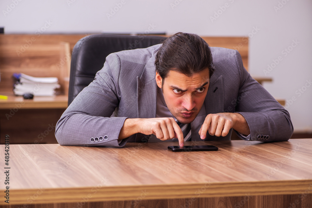 Fototapeta premium Young businessman employee sitting in the office