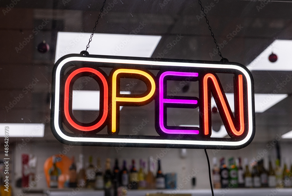 A neon open sign in a shop window. A neon open sign in a shop window.