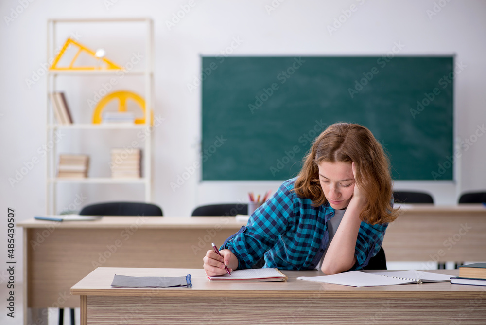 Young female student preparing for exam in the classroom Young female student preparing for exam in the classroom